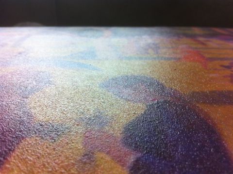 Close view of the coating on top of the fake art. The faux art was printed on a plotter and then coated with Sculpt-or-Coat. You can a fine raised texture and a glare from the light.