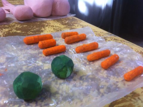 Process shot of a fake food project. Fake carrots and brussel sprouts are carved from wood and painted.