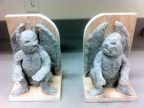 Process shot of a papier mache sculpting project. It is a front view of a pair of gargoyle bookends.