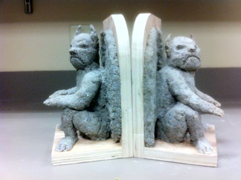 Process shot of a papier mache sculpting project. It is a side view of a pair of gargoyle bookends.