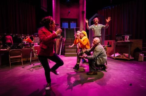 An actor moves in slow motion in a fit of rage. They are lit in a saturate magenta back light to emphasize the heightened mood.